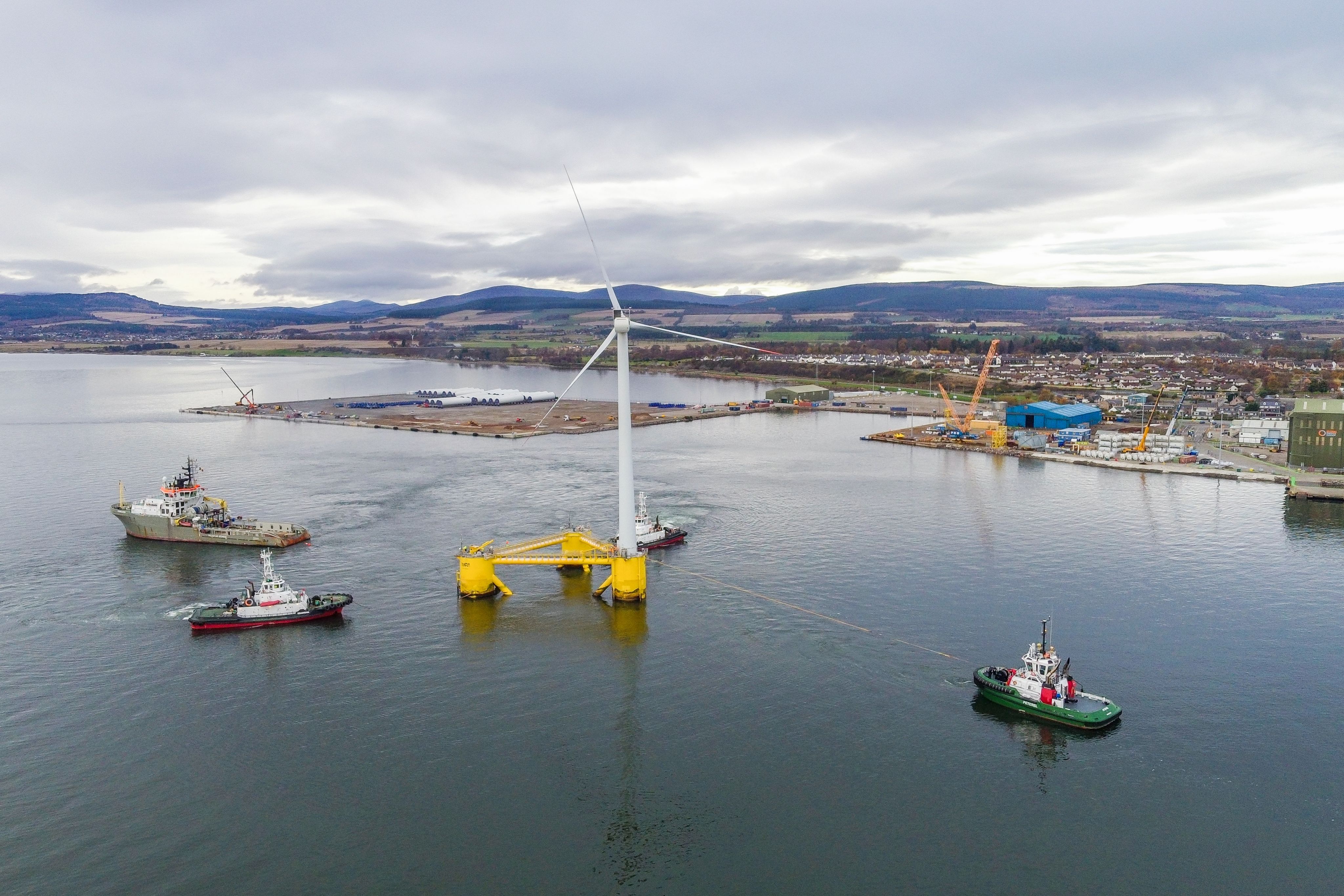 Photo showing offshore wind demonstration unit being towed out to sea at the port of Cromarty Firth.